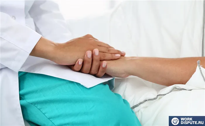 Доктор сидит на кровати и держит женщину за руку
