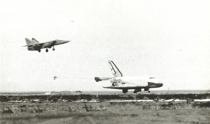Космический корабль «Буран» выпускает тормозные парашюты во время посадки, 15 ноября 1988 года. Над ним – истребитель МиГ-25, контролировавший взлет и посадку корабля